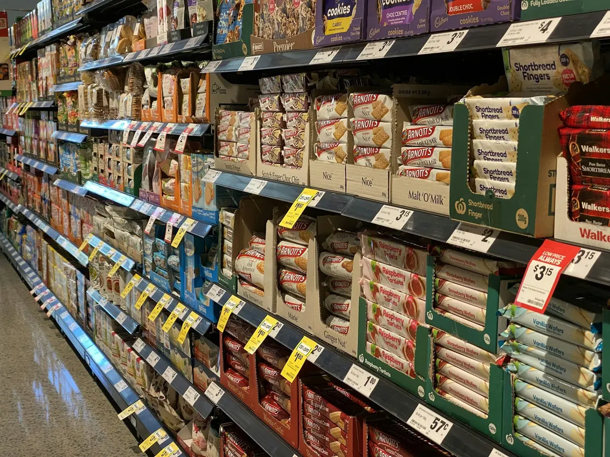 Góndola de supermercado con productos empacados y etiquetas de precio