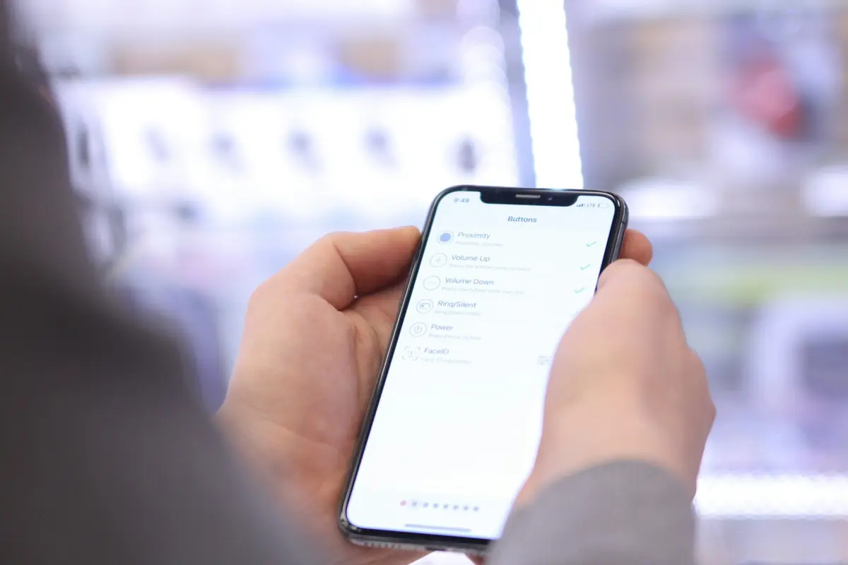 Mano usando un smartphone en una tienda iluminada